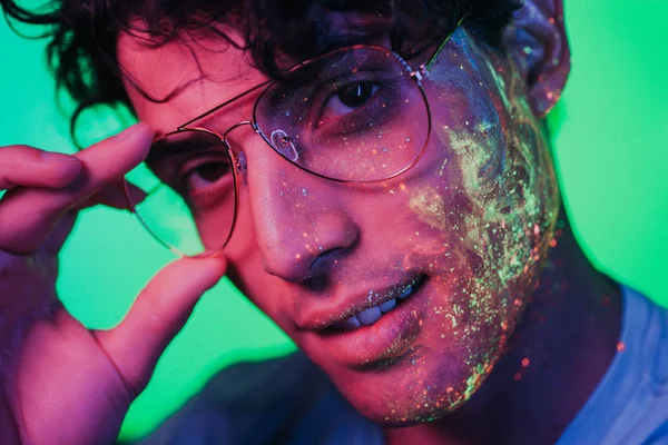 Красивий хлопчик танцює на вечірці з флуоресцентною картиною — стокове фото