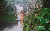 schönes Mädchen, das Spaß an den Wasserfällen in Bali hat. Konzept abo