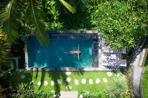 Девочка отдыхает на свежем воздухе в саду с бассейном — стоковое фото