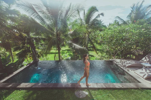 Menina bonita relaxante ao ar livre em seu jardim com piscina — Fotografia de Stock