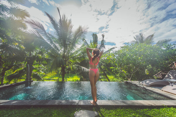 Девочка отдыхает на свежем воздухе в саду с бассейном
