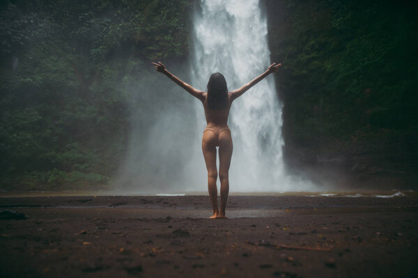 Beautiful girl having fun at the waterfalls in Bali. Concept abo