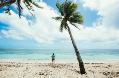 Adam sahilde duran ve bir ile tropikal yer zevk