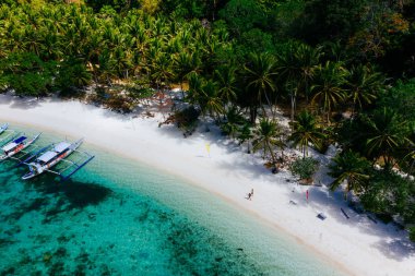 Sahilde vakit geçiriyorum. Beyaz kumda yürüyen insanlar
