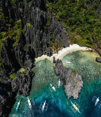 El nido'da küçük bir lagün. Beyaz kumda yürüyen insanlar, 