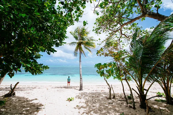 Homem de pé na praia e desfrutar do lugar tropical com um — Fotografia de Stock