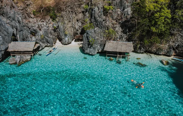 Man kayaking in the twin lagoon between the rocks and fishermen