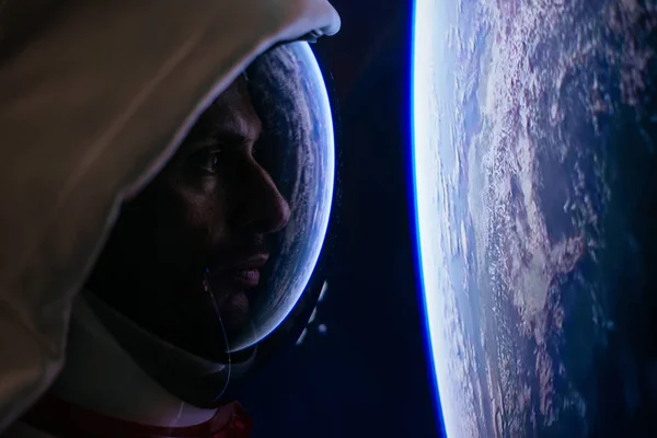 Astronauta olhando para o espaço profundo, galáxia e planetas da janela — Fotografia de Stock