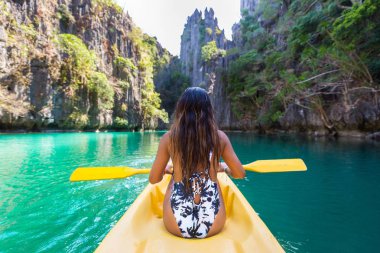 Woman kayaking in the Small Lagoon in El Nido, Palawan, Philippines - Travel blogger exploring south-east asia best places clipart