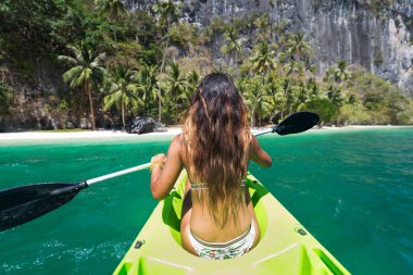 Woman kayaking in the Small Lagoon in El Nido , Philippines clipart