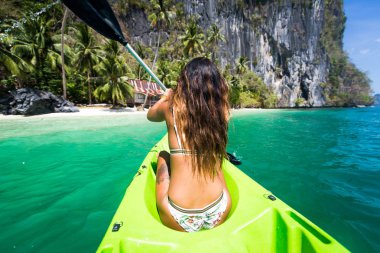 Woman kayaking in the Small Lagoon in El Nido , Philippines clipart