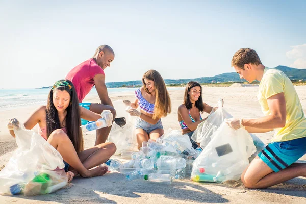 Voluntários coletando plástico na praia — Fotografia de Stock