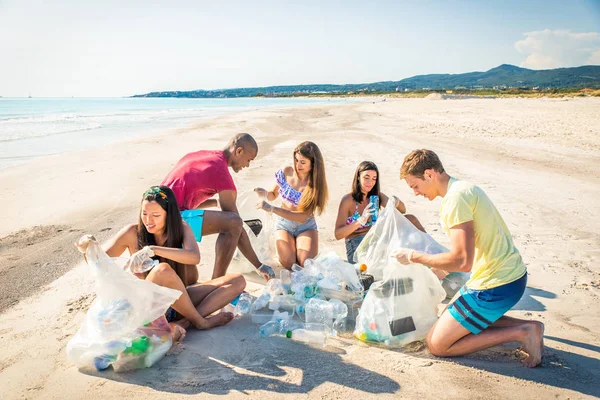 Volontari che raccolgono plastica sulla spiaggia — Foto Stock