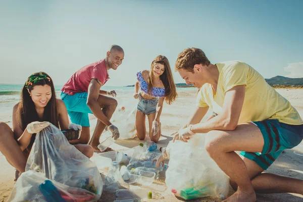 Dobrovolníci sbírání plastů na pláži — Stock fotografie