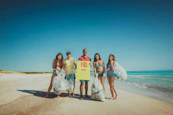 Voluntários coletando plástico na praia — Fotografia de Stock