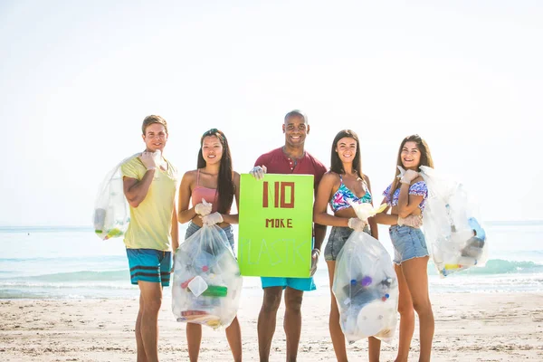Добровольцы собирают пластик на пляже — стоковое фото