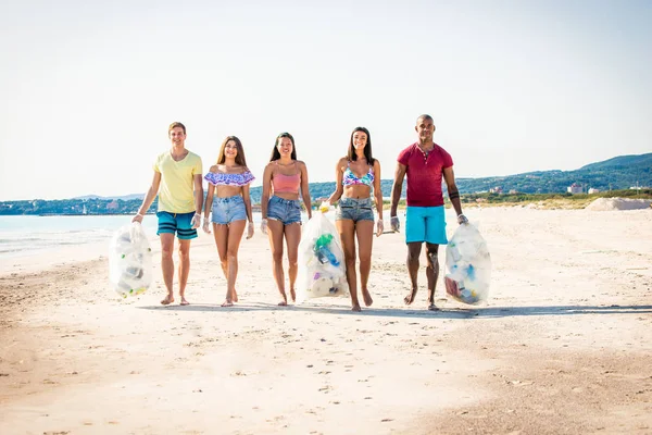 Voluntários coletando plástico na praia — Fotografia de Stock