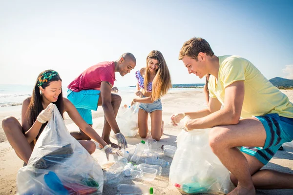 Voluntários coletando plástico na praia — Fotografia de Stock