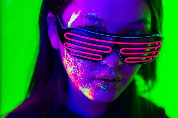 Модель моды с флуоресцентной росписью на лице — стоковое фото