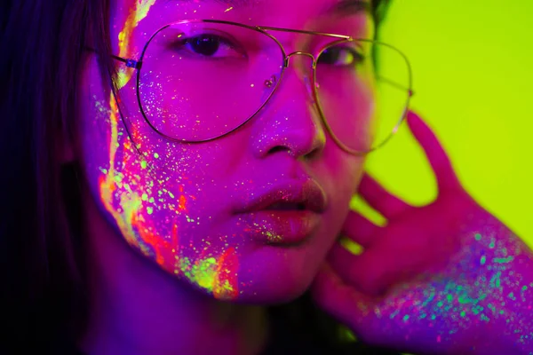 Mode model met fluo schilderij op het gezicht — Stockfoto