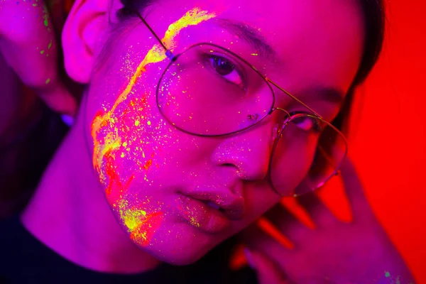 Fashion model with fluo painting on the face