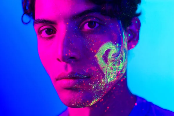 Fashion model with fluo painting on the face