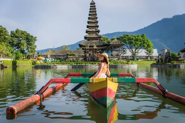 Молода жінка мандрівника веслування на дерев'яному човні в Пура Ульун Danu — стокове фото