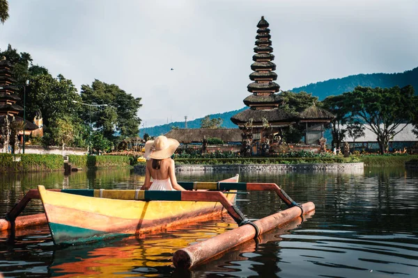 Viajante joven remando en un barco de madera en Pura Ulun Danu — Foto de Stock