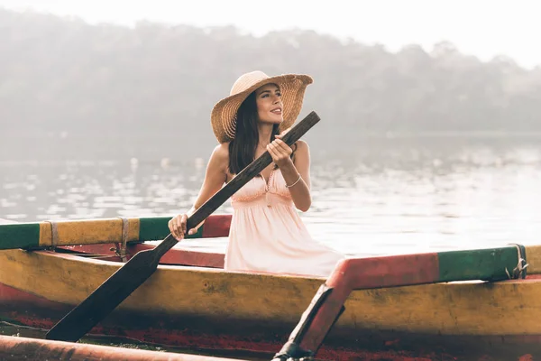 Giovane viaggiatrice remare su una barca di legno a Pura Ulun Danu — Foto Stock