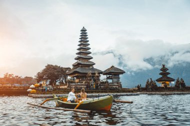 Pura Ulun Danu Bratan bir tahta teknede genç çift kürek