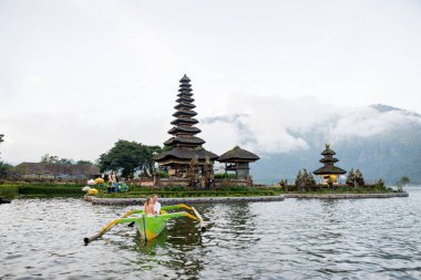 Pura Ulun Danu Bratan bir tahta teknede genç çift kürek