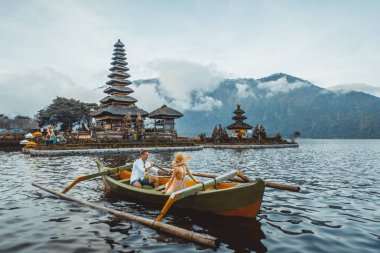 Pura Ulun Danu Bratan bir tahta teknede genç çift kürek