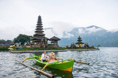 Pura Ulun Danu Bratan bir tahta teknede genç çift kürek