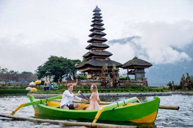 Pura Ulun Danu Bratan bir tahta teknede genç çift kürek