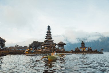 Pura Ulun Danu Bratan bir tahta teknede genç çift kürek