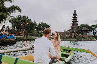 Pura Ulun Danu Bratan bir tahta teknede genç çift kürek