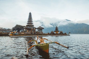 Pura Ulun Danu Bratan bir tahta teknede genç çift kürek