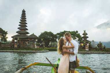 Pura Ulun Danu Bratan bir tahta teknede genç çift kürek