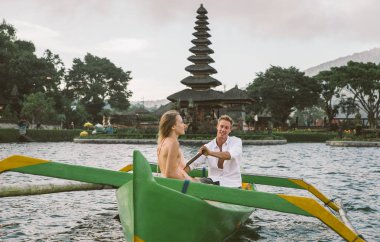 Pura Ulun Danu Bratan bir tahta teknede genç çift kürek