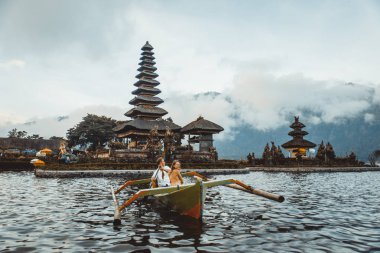 Pura Ulun Danu Bratan bir tahta teknede genç çift kürek