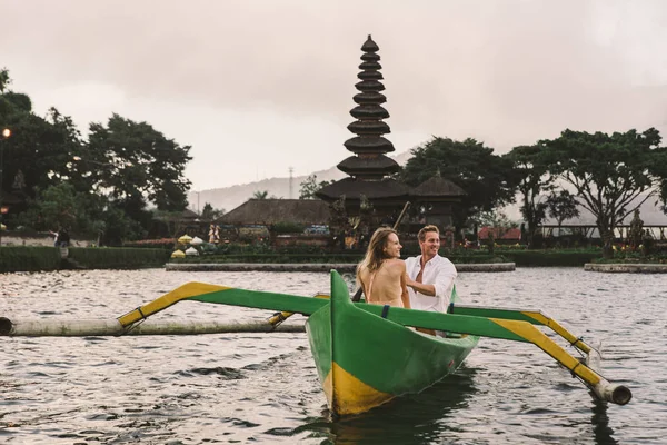 Junges Paar paddelt auf einem Holzboot bei pura ulun danu bratan — Stockfoto