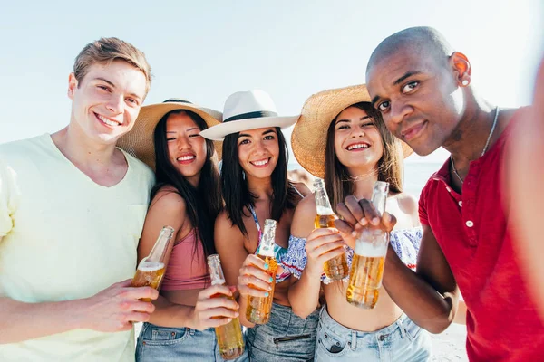 Grupo de amigos que passam tempo na praia juntos comemorando — Fotografia de Stock