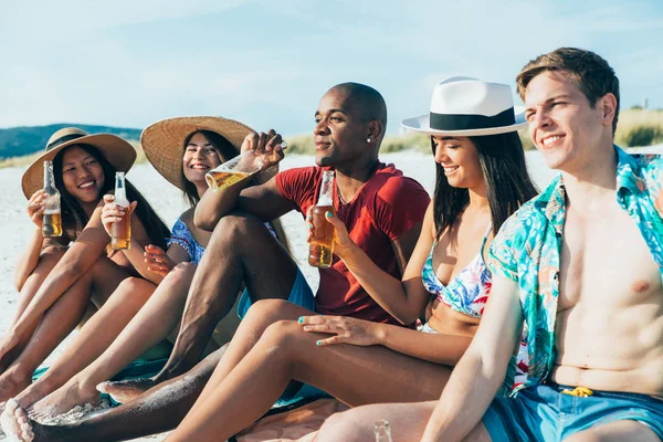 Grupo de amigos que pasan tiempo juntos en la playa celebrando — Foto de Stock