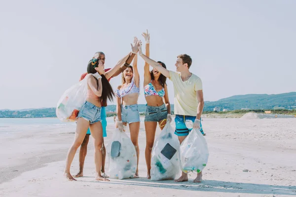 Группа друзей активистов собирает пластиковые отходы на пляже — стоковое фото