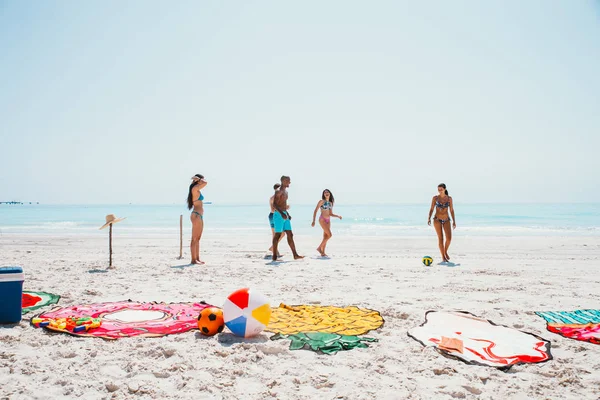 Группа друзей проводит время на пляже вместе празднуя — стоковое фото