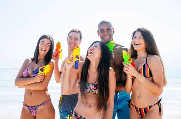 Group of friends spending time on the beach together celebrating — Stock Photo, Image