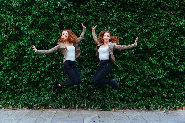 Tvillingsystrar limning utomhus — Stockfoto