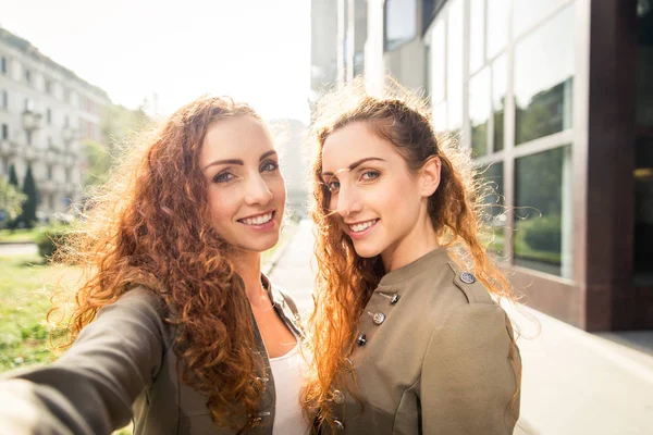 Tweeling zusters lijmen buitenshuis — Stockfoto
