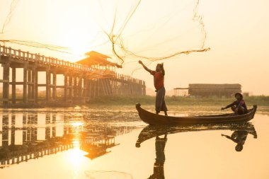 Myanmar balıkçısı göle ağ atıyor. 