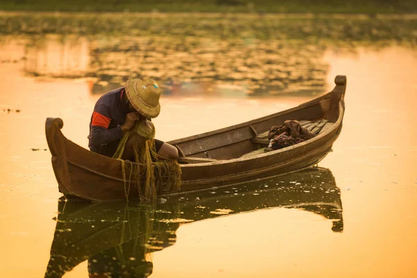 Myanmar balıkçısı göle ağ atıyor. 